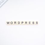 WordPressのイメージ。WordPressのロゴの隣に、キーボードとスマートフォンが表示されている。